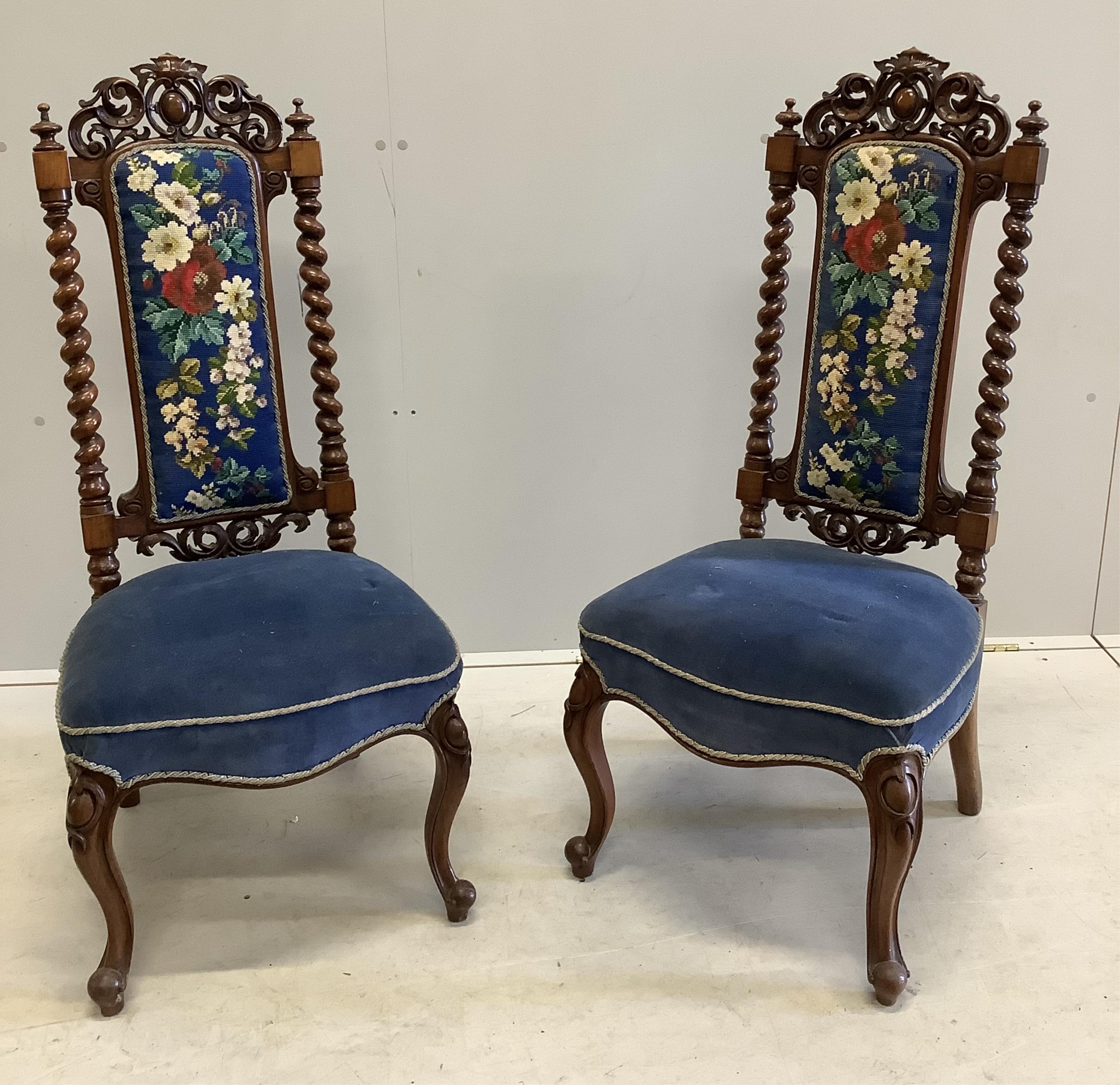 A pair of Victorian carved walnut side chairs with polychrome floral upholstered backs, width 46cm, depth 40cm, height 104cm. Condition - fair to good